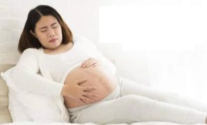 Беременная держится за живот от боли
